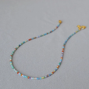 Close-up of faceted colorful beads necklace with gold lobster clasp and extension chain