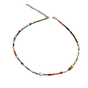 Collier fait main en perles colorées avec perle d'eau douce et style bohème sur fond blanc