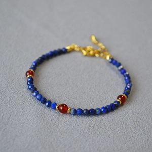 Detail of beaded necklace with lapis lazuli, red agate and golden lobster clasp