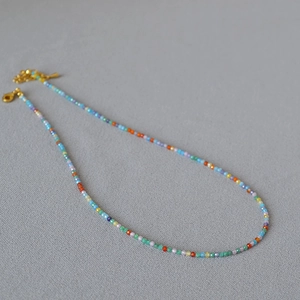 Detail of colorful faceted zircon beaded necklace with gold lobster clasp and extension chain