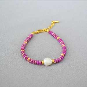 Detail view of lilac stones and freshwater pearl bracelet with gold lobster clasp and chain
