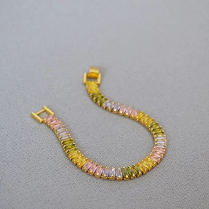 Golden buckle bracelet featuring a gradient of rectangular rainbow cubic zirconia stones