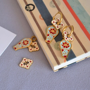 Vue détaillée de boucles d'oreilles en émail artisanal avec motifs de fleurs vintage