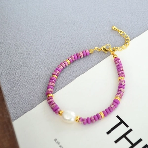 Detailed shot of lilac natural stone beads with a white freshwater pearl and gold clasp