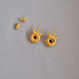 Cute gold-plated unicorn donut stud earrings with rose enamel on gray textured background