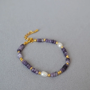 Macro detail of lilac stone beads and freshwater pearls on an elegant beaded bracelet