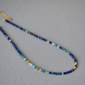Close-up of faceted lapis and multi-color crystal beads with gold metal accents