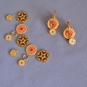Détails de boucles d'oreilles en laiton émaillé à la main avec pendentifs floraux dorés