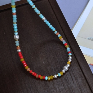 Macro view of colorful Amazonite beads and white pearls with golden spacer details