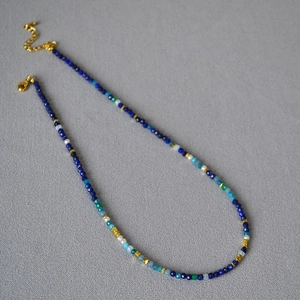 Detailed view of Lapis Lazuli and pearl beaded necklace with gold lobster clasp