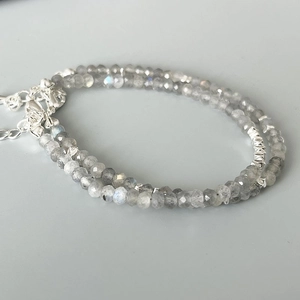 Macro detail of faceted grey moonstone beads and silver-toned geometric metal spacers