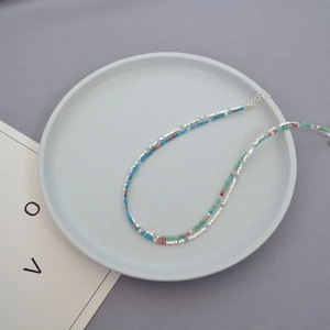 Macro detail of colorful beaded necklace with silver accents and adjustable clasp