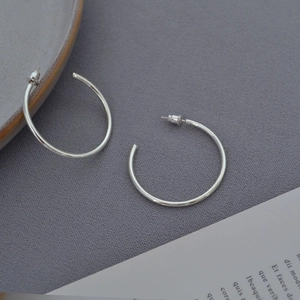 Minimalist silver plated brass C-shaped hoop earrings with high polish finish on grey background