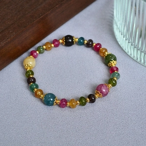 Detailed macro view of colorful tourmaline beads with intricate gold filigree spacers