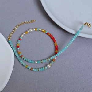 Detail shot of a colorful amazonite beaded necklace with pearls and gold lobster clasp
