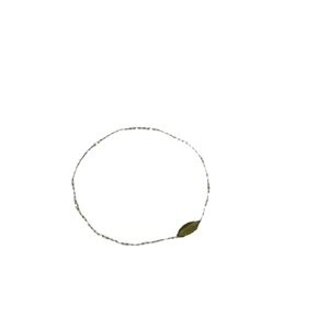 Minimalist elastic bracelet with olive green beads and a golden leaf charm on white backdrop