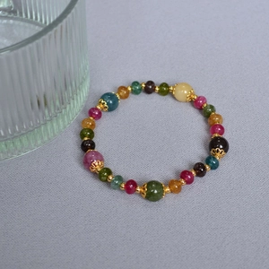 Close-up of handmade tourmaline beaded bracelet with gold flower spacers and metal beads