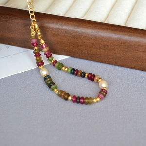 Detail of colorful tourmaline beaded bracelet with freshwater pearls and gold lobster clasp