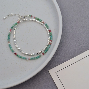 Detail of layered beaded necklace featuring natural stones, pearls and silver beads