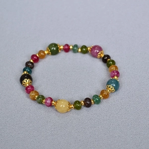 Detailed shot of multi-colored tourmaline beaded bracelet with gold hollow flower spacers