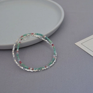 Close-up of beaded necklace with turquoise, pink stones and silver clasp detail