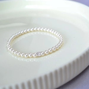 Elegant white pearl bracelet featuring a square-cut sparkling zircon on a ceramic tray