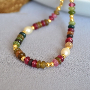 Macro detail of colorful tourmaline beads and pearls on an elegant vintage style bracelet