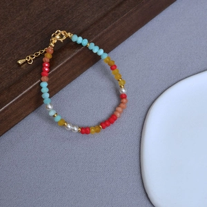 Detail of colorful faceted amazonite beads and pearls on a necklace with gold lobster clasp