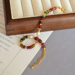 Detail of colorful tourmaline beads and white freshwater pearls on a gold-plated bracelet