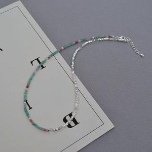 Macro view of colorful beaded necklace with natural stones and silver lobster clasp detail