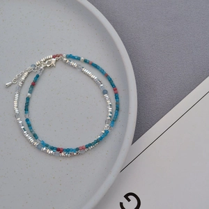Close-up of double-layer beaded necklace with blue, pink gems and silver accent beads