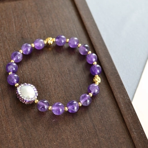 Détail macro du bracelet en améthyste avec perle baroque et accents dorés