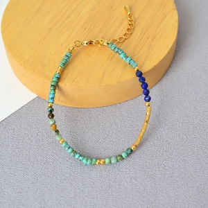 Detail view of Bohemian turquoise and blue stone beaded bracelet with golden metal tube accent