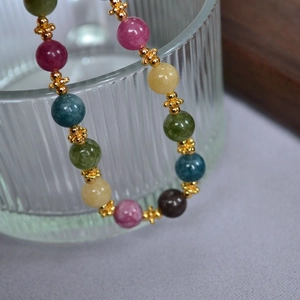 Detail of handmade multicolor gemstone beaded bracelet with vintage gold floral spacers