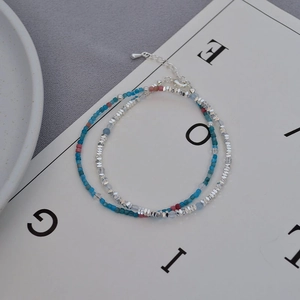 Detail of layered double-strand bracelet with multicolor beads and silver faceted beads