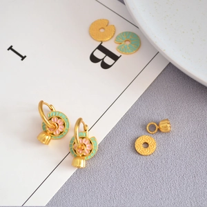 Détail de boucles d'oreilles lotus en émail avec pendentifs en laiton plaqué or