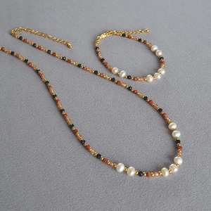 Detail view of handmade baroque pearl necklace and bracelet set with gold beads