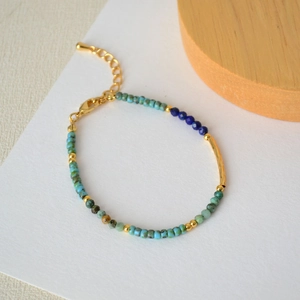 Detail of bohemian turquoise and blue beaded bracelet with adjustable gold chain and clasp