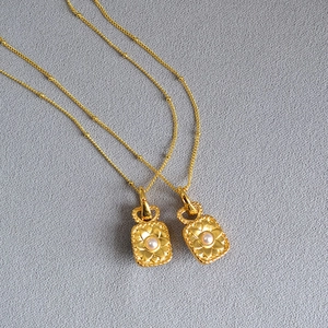 Détail du collier plaqué or vintage avec pendentif floral et perle incrustée
