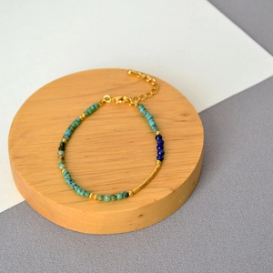 Detailed view of bohemian turquoise and lapis lazuli beaded bracelet with gold hammer tube
