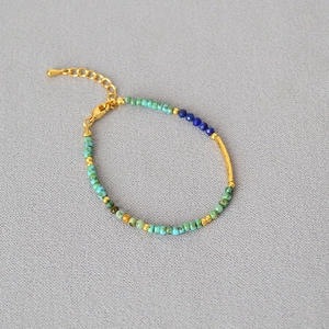 Detailed close-up of Bohemian beaded bracelet with turquoise stones and gold clasp