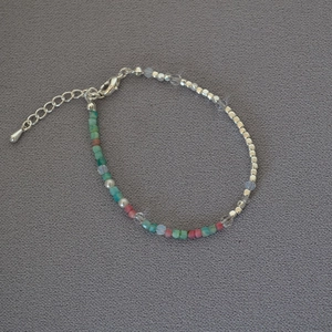 Detail view of handmade beaded necklace with silver cubes and colorful gemstones