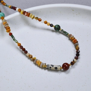 Collier bohème en pierres naturelles multicolores avec intercalaires dorés sur plateau