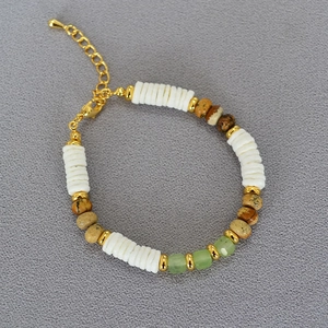 Detailed macro view of white shell and green gemstone beaded necklace with golden lobster clasp