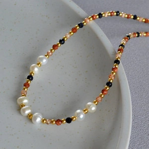 Detail of baroque pearl necklace with gold beads and sparkling blue sandstone beads