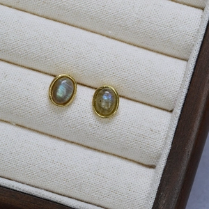 Macro detail of oval labradorite earrings in gold brass bezel with blue fire flash