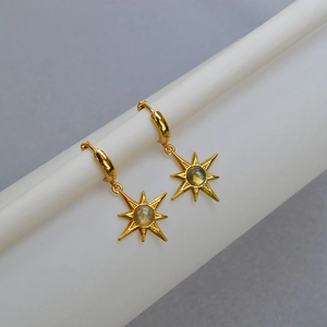 Minimalist 18K gold starburst earrings featuring natural labradorite stones on a stand