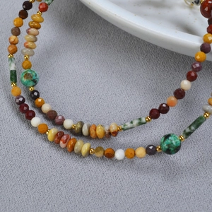 Détail macro du collier en pierres naturelles avec turquoise, agate et perles dorées