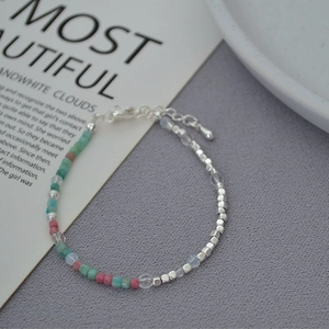 Close-up of handmade necklace with silver beads, pink and green stones, and pearls