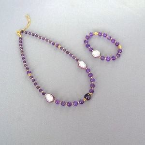Détail d'un ensemble collier et bracelet en améthyste avec touches dorées et perles baroques